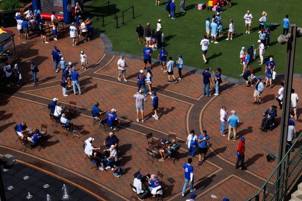 Fans walk outside the ballpark before the Cubs host the...