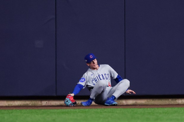 Chicago Cubs outfielder Pete Crow-Armstrong (4) falls after trying to...