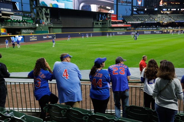 Fans watch Chicago Cubs players warm up before they play...