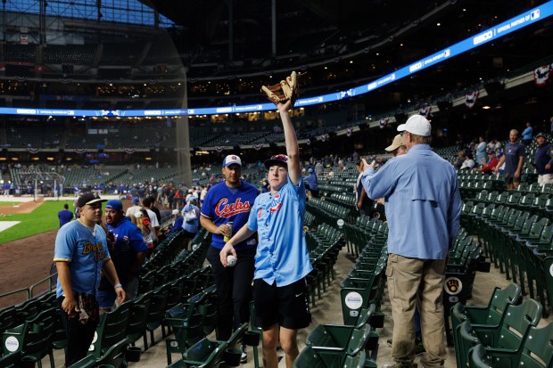 Fans watch Chicago Cubs players warm up before they play...