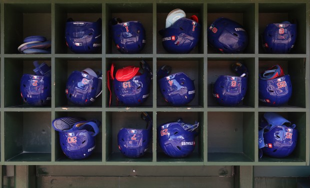 Cubs players' helmets are placed on the shelf before the...