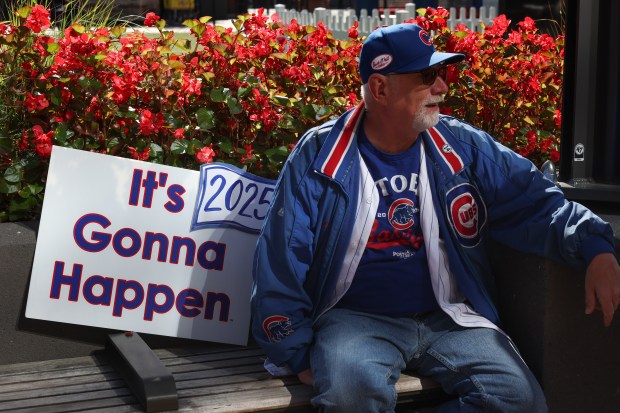 Bob Wozny sits with a sign before the NLDS Game...