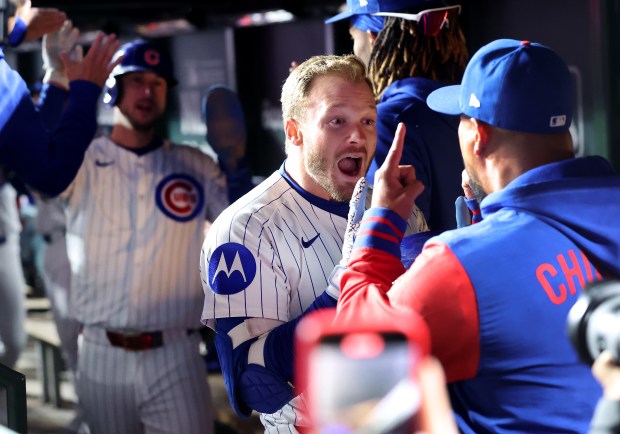 Cubs left fielder Ian Happ celebrates with teammates in the...