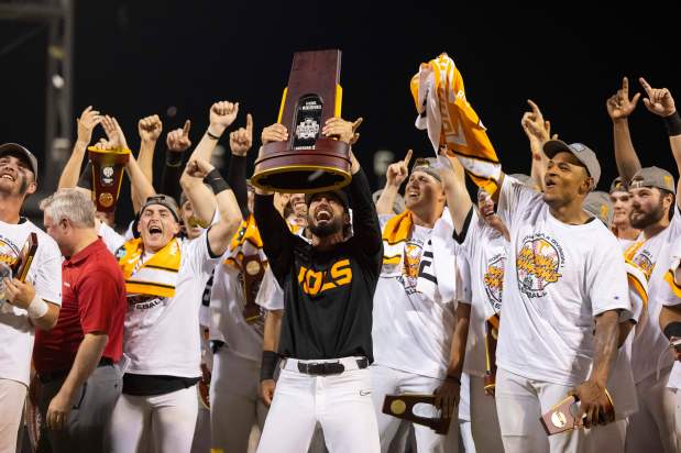 FILE - Tennessee coach Tony Vitello, center, hoists the championship trophy following his team's 6-5 victory against Texas A&M in Game 3 of the NCAA College World Series baseball finals in Omaha, Neb., June 24, 2024. (AP Photo/Rebecca S. Gratz, File)