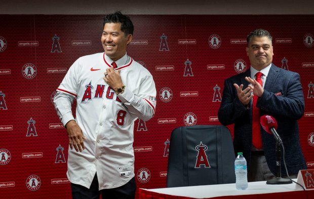 New Angels manager Kurt Suzuki, left, puts his jersey on...