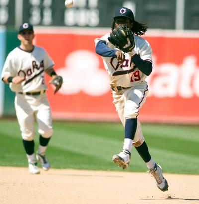 Dressed in an Oakland Oaks uniform on '50s Turn Back the Clock Day, Oakland Athletics second baseman Jemile Weeks, right, throws on the run in time to get Seattle Mariners' Dustin Ackley at first base during the tenth inning of a Major League Baseball game, Sunday, July 8, 2012 at O.co Coliseum in Oakland, Calif. The A's won in 13 innings, 2-1. (D. Ross Cameron/Staff)
