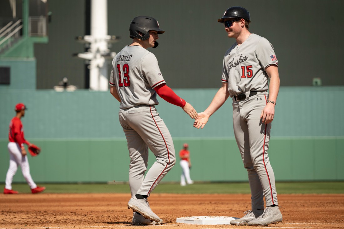 Two Northeastern baseball players talk near the field during the spring training exhibition game against the Red Sox at JetBlue Park.