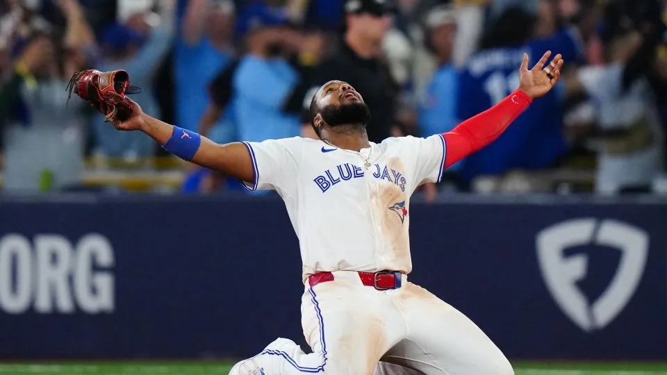 Vladimir Guerrero Jr. of the Toronto Blue Jays celebrates on his knees after winning Game 7 of the ALCS. - Daniel Shirey/MLB/Getty Images