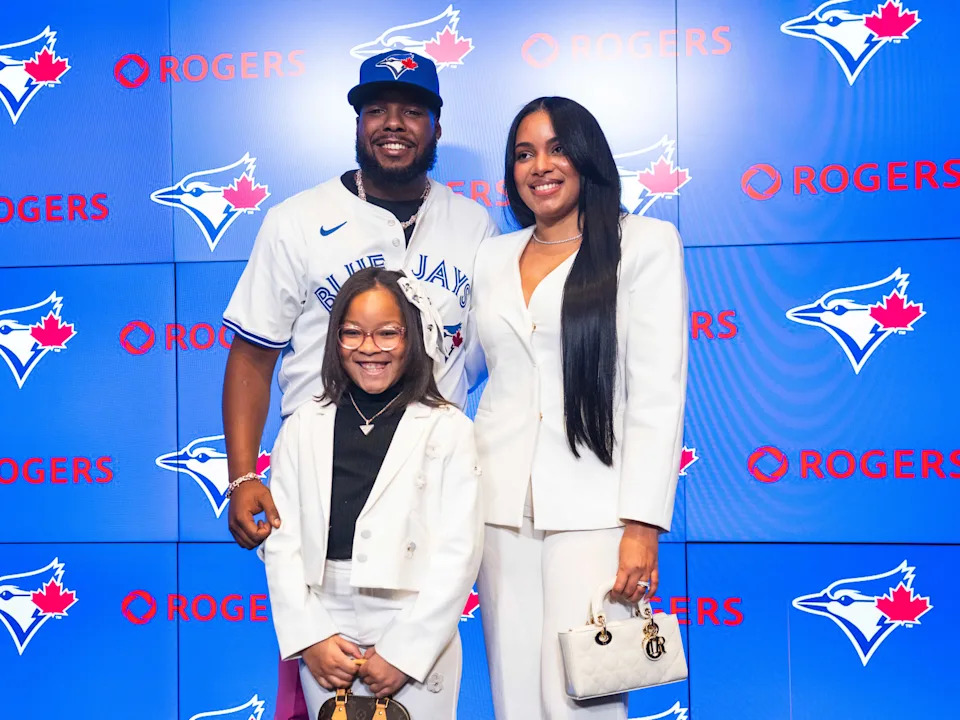 TORONTO, ON - APRIL 14: Vladimir Guerrero Jr. #27 of the Toronto Blue Jays poses with his wife, Nathalie, and their daughter, Vlaimel, after signing his contract extension during a press conference at Rogers Centre on April 14, 2025 in Toronto, Ontario, Canada. (Photo by Mark Blinch/Getty Images)