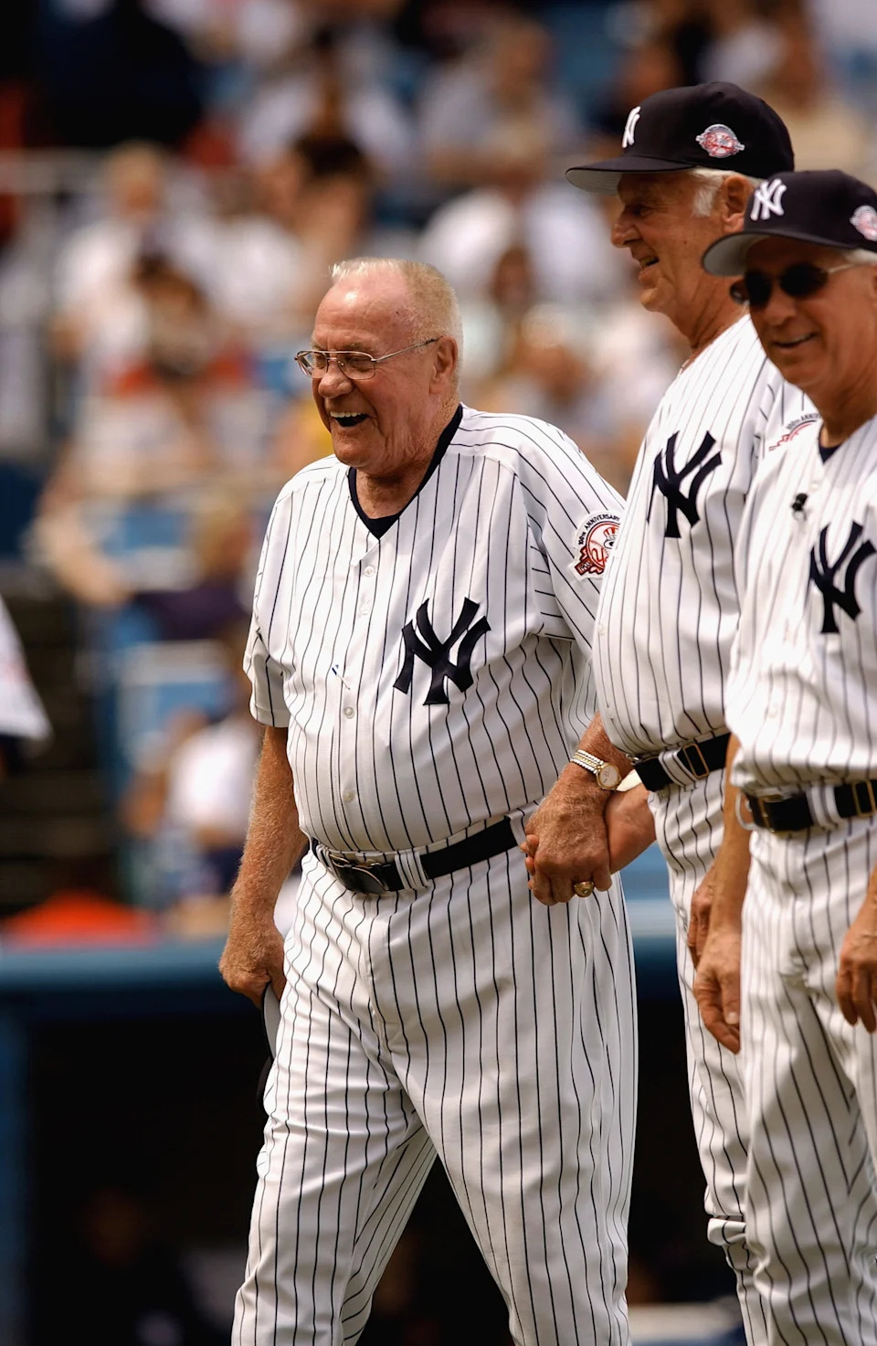 New York Yankee legend Hank Bauer laughs as he shakes hands with fellow former Yankee Don Larsen (C) as he stands next to former Yankee Bobby Mercer.