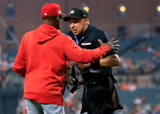 Angels manager Ron Washington, left, speaks to home plate umpire...