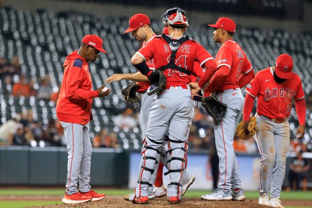 Angels manager Ron Washington retrieves the ball from relief pitcher...
