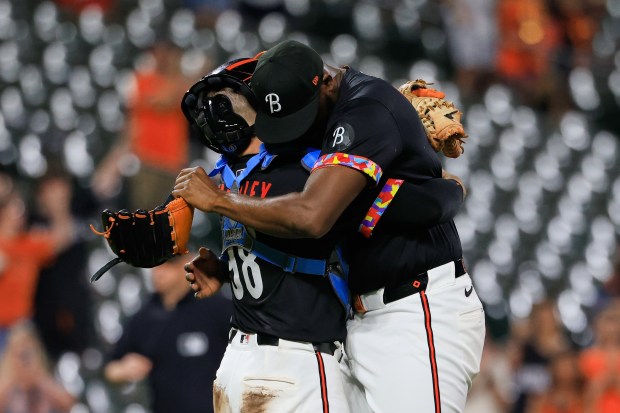 Baltimore Orioles relief pitcher Félix Bautista, right, and catcher Maverick...