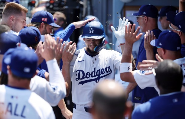 The Dodgers’ Andy Pages is congratulated in the dugout after...