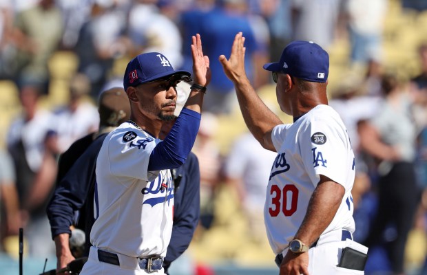 Dodgers shortstop Mookie Betts, left, celebrates with Manager Dave Roberts...