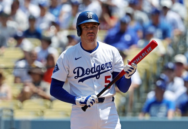 The Dodgers’ Freddie Freeman holds his bat, with his son...
