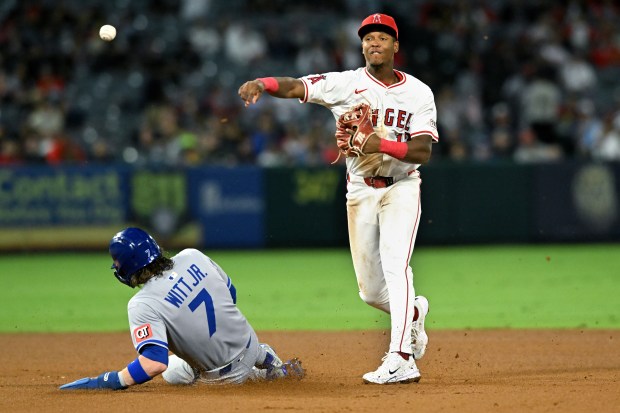 Angels shortstop Denzer Guzman throws to first base after forcing...