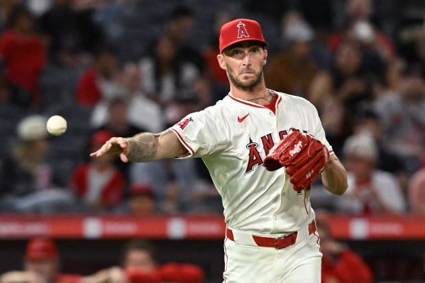 Angels relief pitcher Connor Brogdon throws to first base for...