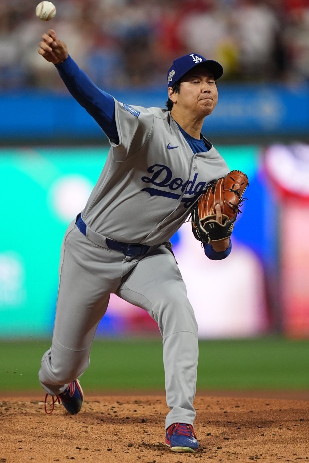 Dodgers starting pitcher Shohei Ohtani throws to the plate during...
