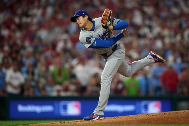Dodgers starting pitcher Shohei Ohtani throws to the plate during...