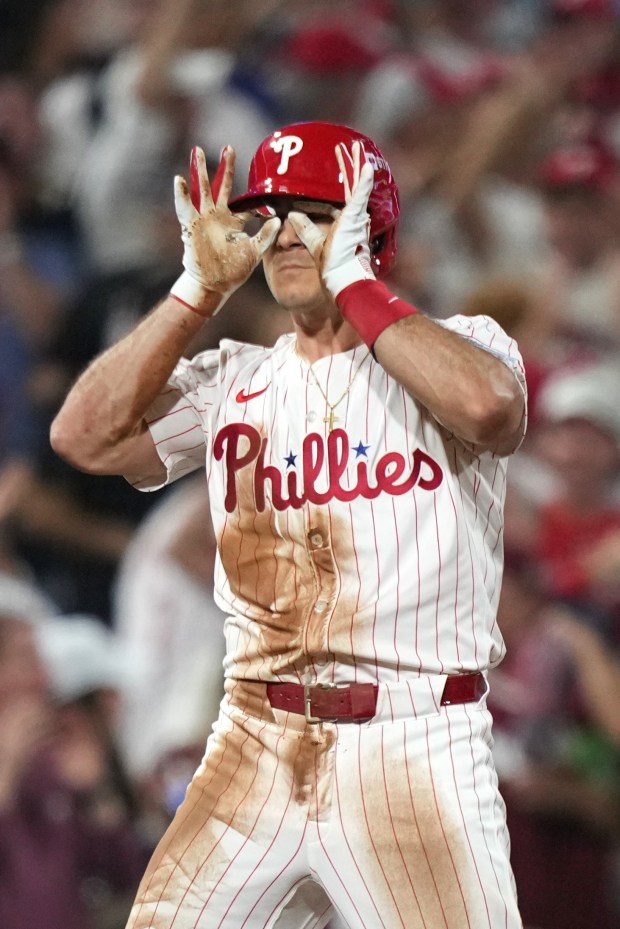 Philadelphia Phillies’ J.T. Realmuto reacts after hitting a two-run triple...
