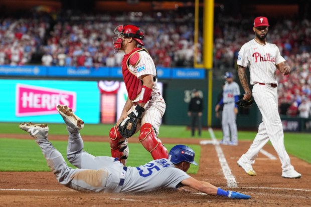 The Dodgers’ Tommy Edman scores past Philadelphia Phillies catcher J.T....