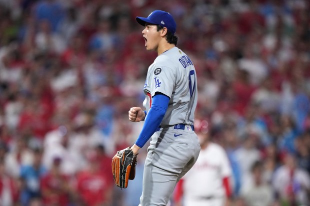 Dodgers starting pitcher Shohei Ohtani reacts after striking out Philadelphia...
