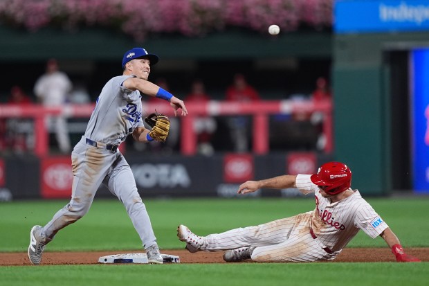 Los Angeles Dodgers second baseman Tommy Edman makes the throw...