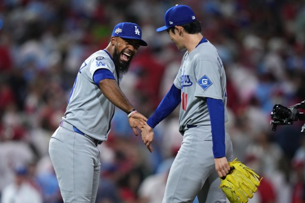 Dodgers outfielder Teoscar Hernández, left, and relief pitcher Roki Sasaki...