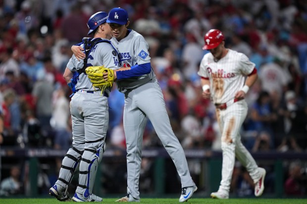 Dodgers catcher Will Smith, left, and relief pitcher Roki Sasaki...