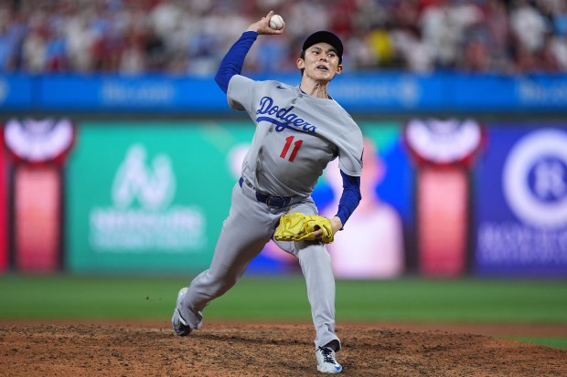 Dodgers relief pitcher Roki Sasaki throws to the plate during...