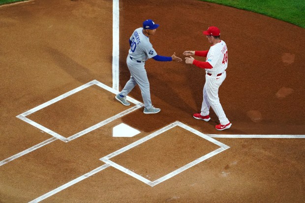 Dodgers manager Dave Roberts, left, and Philadelphia Phillies manager Rob...