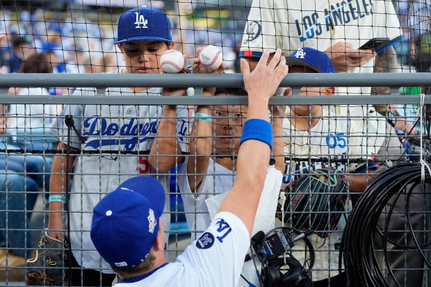 Dodgers right fielder Alex Call autographs a baseball for a...