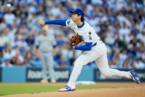 Dodgers starting pitcher Shohei Ohtani throws to the plate throws...