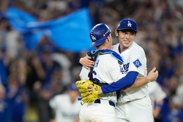 Dodgers relief pitcher Roki Sasaki, right, and catcher Will Smith...