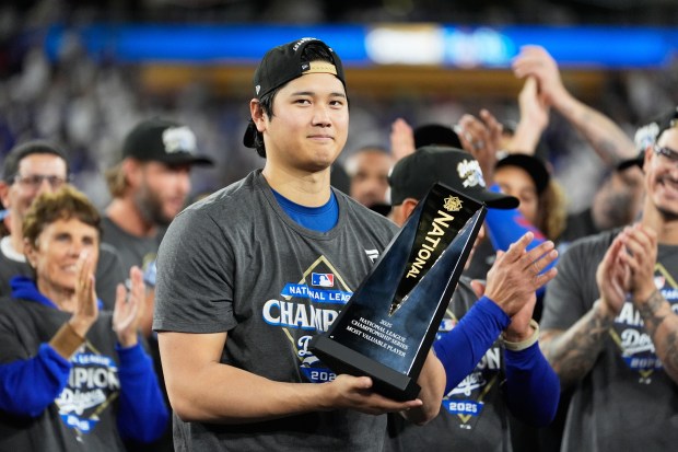 Dodgers star Shohei Ohtani celebrates with the NLCS MVP trophy...
