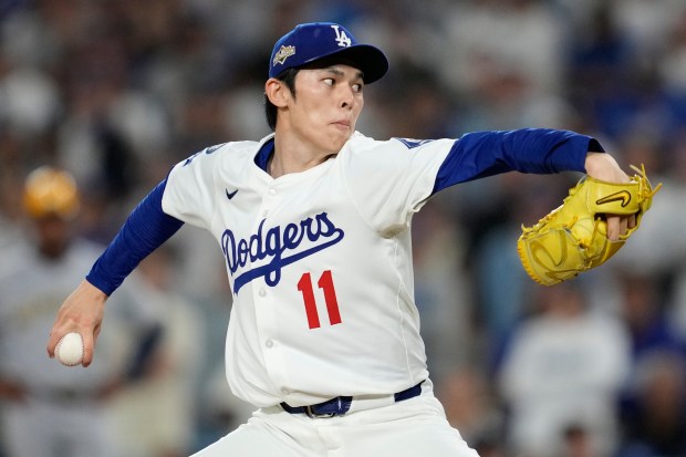 Dodgers relief pitcher Roki Sasaki throws to the plate during...