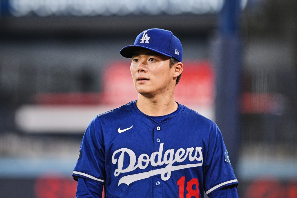 Dodgers player wearing a blue cap and jersey with number 18.
