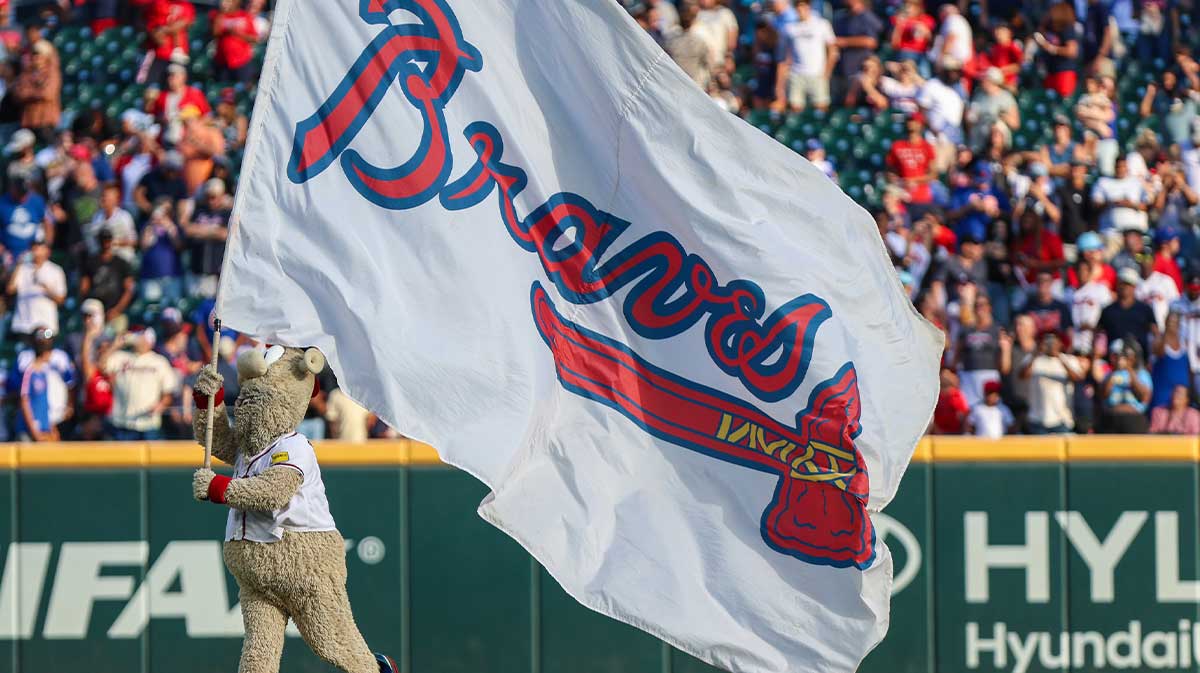 The Atlanta Braves mascot Blooper runs with the Atlanta Braves flag after a victory against the Pittsburgh Pirates at Truist Park.