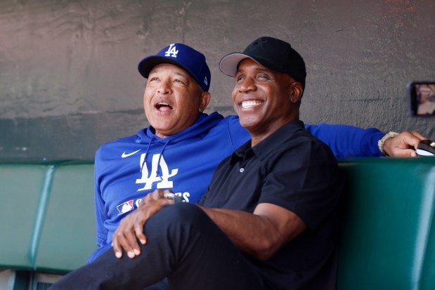 Los Angeles Dodgers manager Dave Roberts sits next to former San Francisco Giant Barry Bonds before a game between the Los Angeles Dodgers and the San Francisco Giants at Oracle Park in San Francisco, Calif., on Saturday, July 12, 2025. (Shae Hammond/Bay Area News Group)
