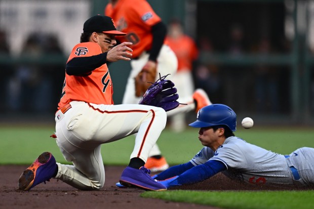 Los Angeles Dodgers' Hyeseong Kim (6) steals second base as San Francisco Giants' Willy Adames (2) drops the ball while attempting the tag in the third inning of their MLB game at Oracle Park in San Francisco, Calif., on Friday, July 11, 2025. (Jose Carlos Fajardo/Bay Area News Group)