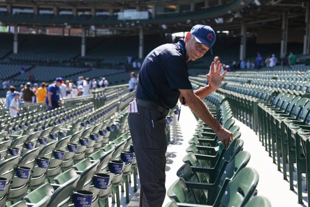 A worker wipes off seats before Game 1 of the...