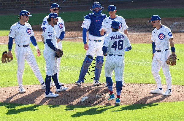 Cubs manager Craig Counsell hands the baseball to relief pitcher...