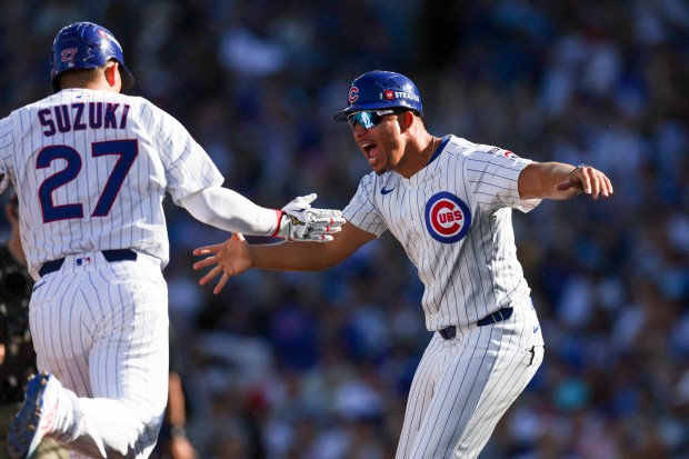 Chicago Cubs third base coach Quintin Berry high-fives Cubs outfielder...