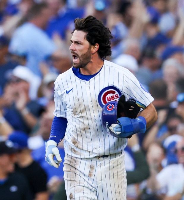 Cubs shortstop Dansby Swanson celebrates after scoring on sacrifice fly...