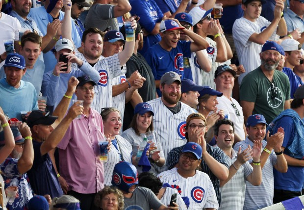 Fans celebrate Michael Busch's home run in the seventh inning...