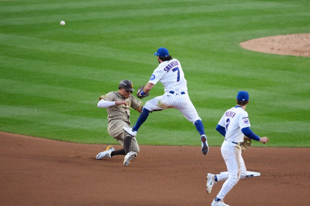 Cubs shortstop Dansby Swanson (7) turns a double play as...