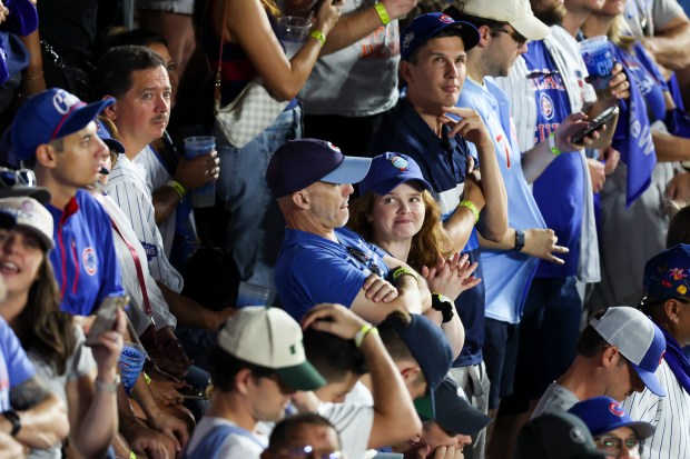 Cubs fans wait in anticipation with two men on base...