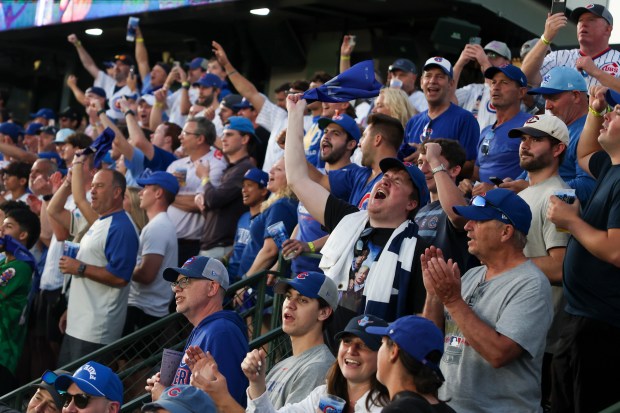 Fans sing “Take Me Out to the Ball Game” in...
