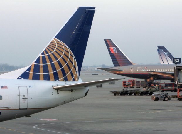 A Continental Airlines plane pushes back from Terminal 2 at Chicago's O'Hare International Airport on Dec. 13, 2006, with United Airlines planes at Terminal 1 in the background. (Charles Cherney/Chicago Tribune)